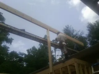 Carpenter setting a ridge beam over a new addition frame — Ice Dam Removal by Roofing Brothers in Dougherty